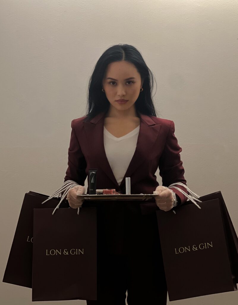Brenda Anura Londoh holding LON & GIN products on a silver tray
